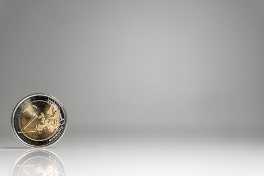 A detailed image of a 2 Euro coin on a reflective surface with ample copy space.