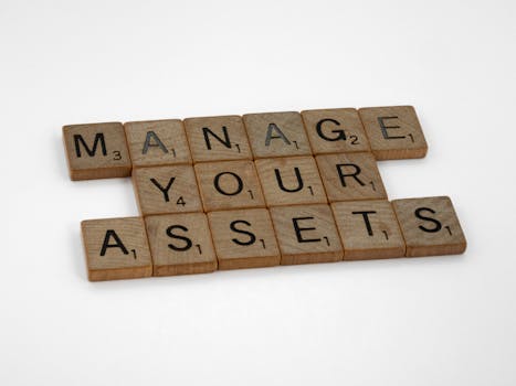 Wooden tiles spelling 'Manage Your Assets' offer conceptual business advice.